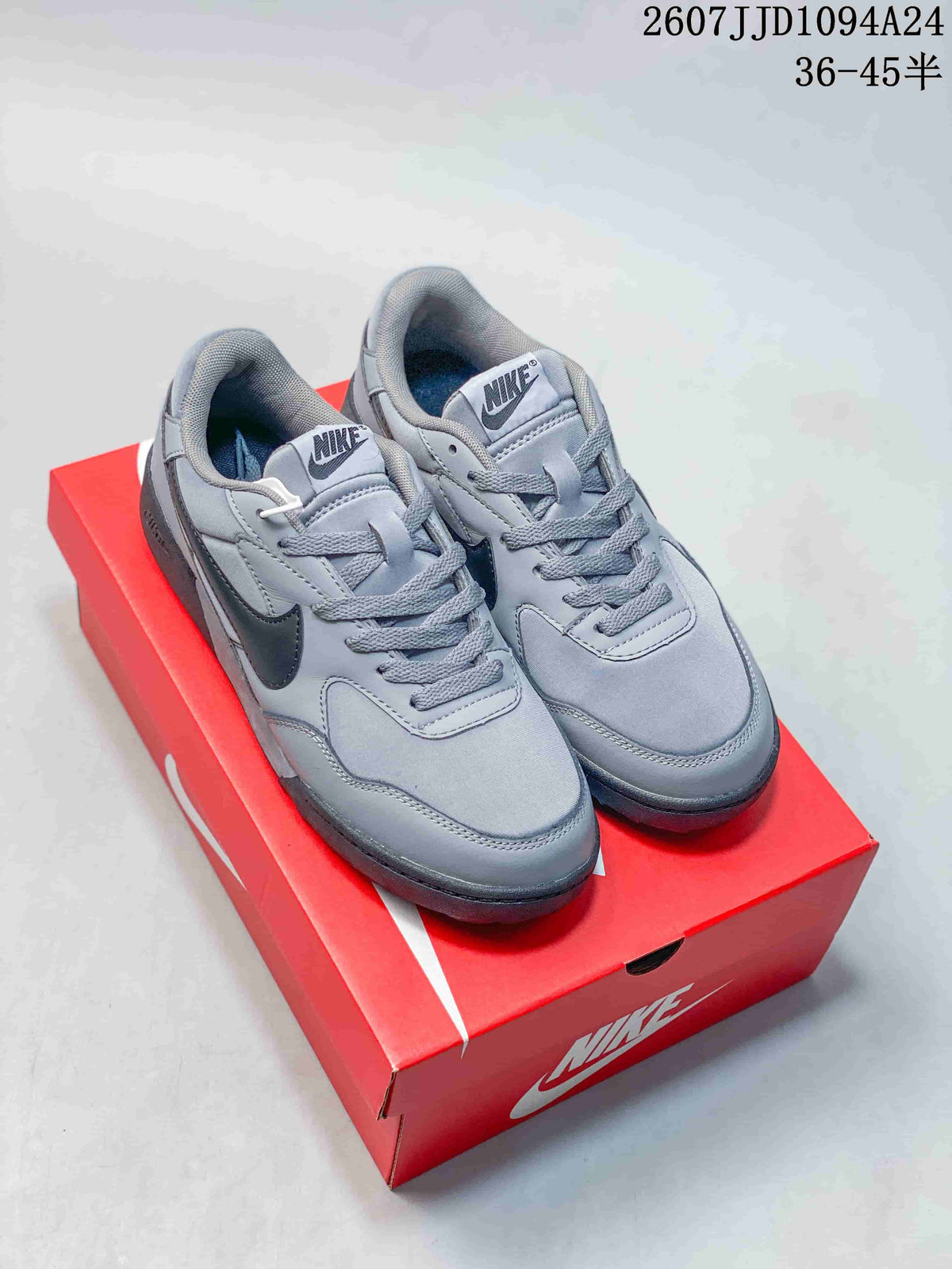 Pair of gray Nike Terra Manta Suede sneakers displayed on a red Nike shoebox.