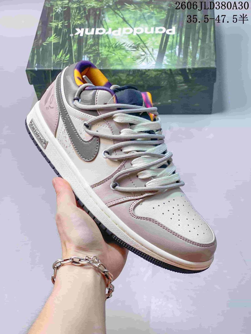 Angled side view of a pink and gray low-top sneaker with a gray side logo and contrasting collar lining.