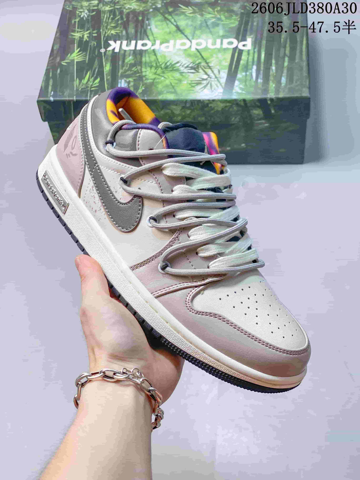 Angled side view of a pink and gray low-top sneaker with a gray side logo and contrasting collar lining.