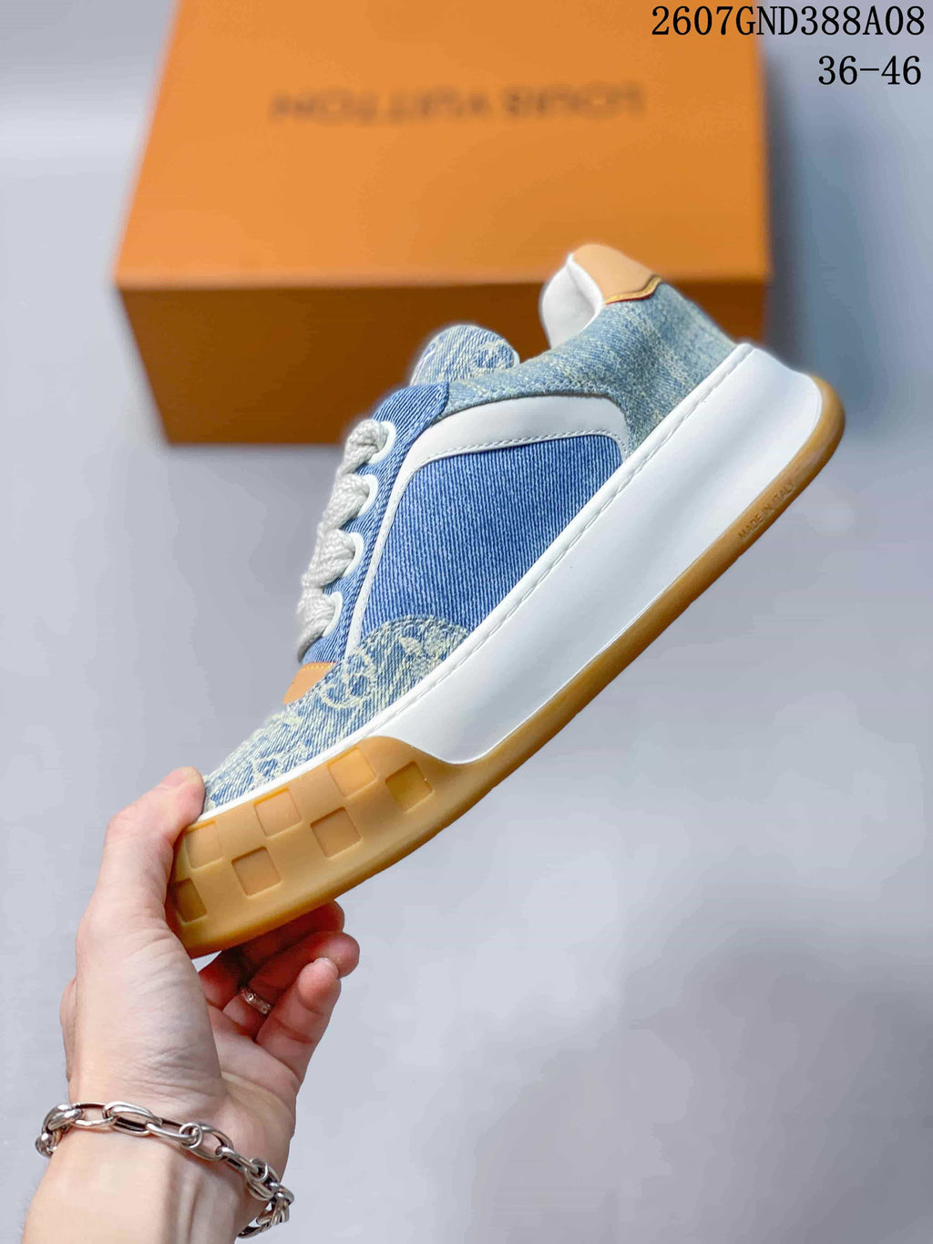 Side view showing the blue patterned upper, white overlays, white midsole, and gum-colored outsole.