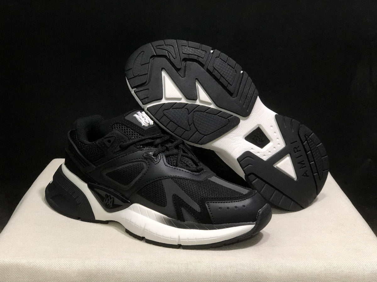 Sneaker outsole view showing the black-and-white tread pattern and AMIRI branding.