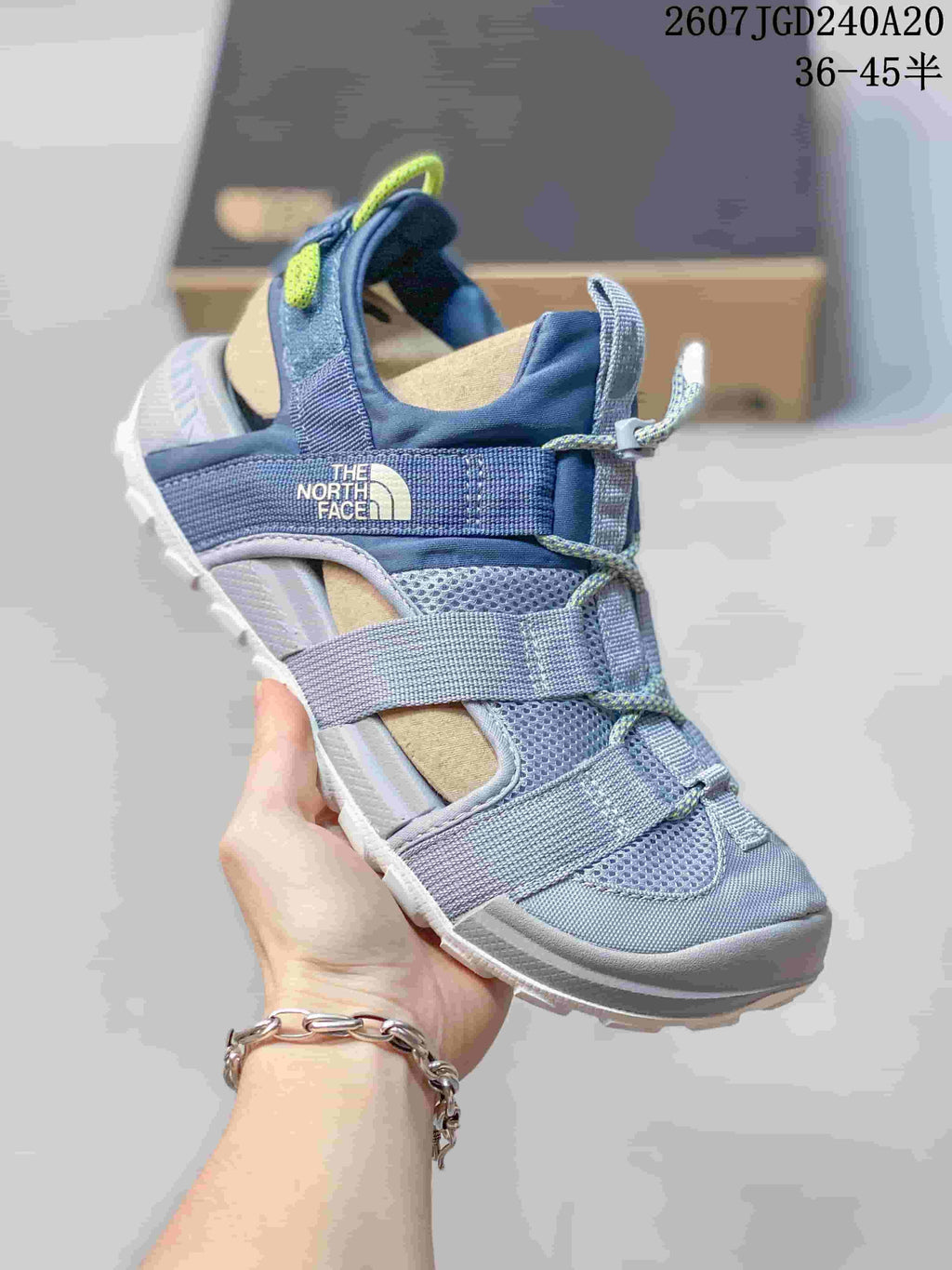 Angled side view of the blue The North Face sandal showing the open design, webbing straps and branded side panel.