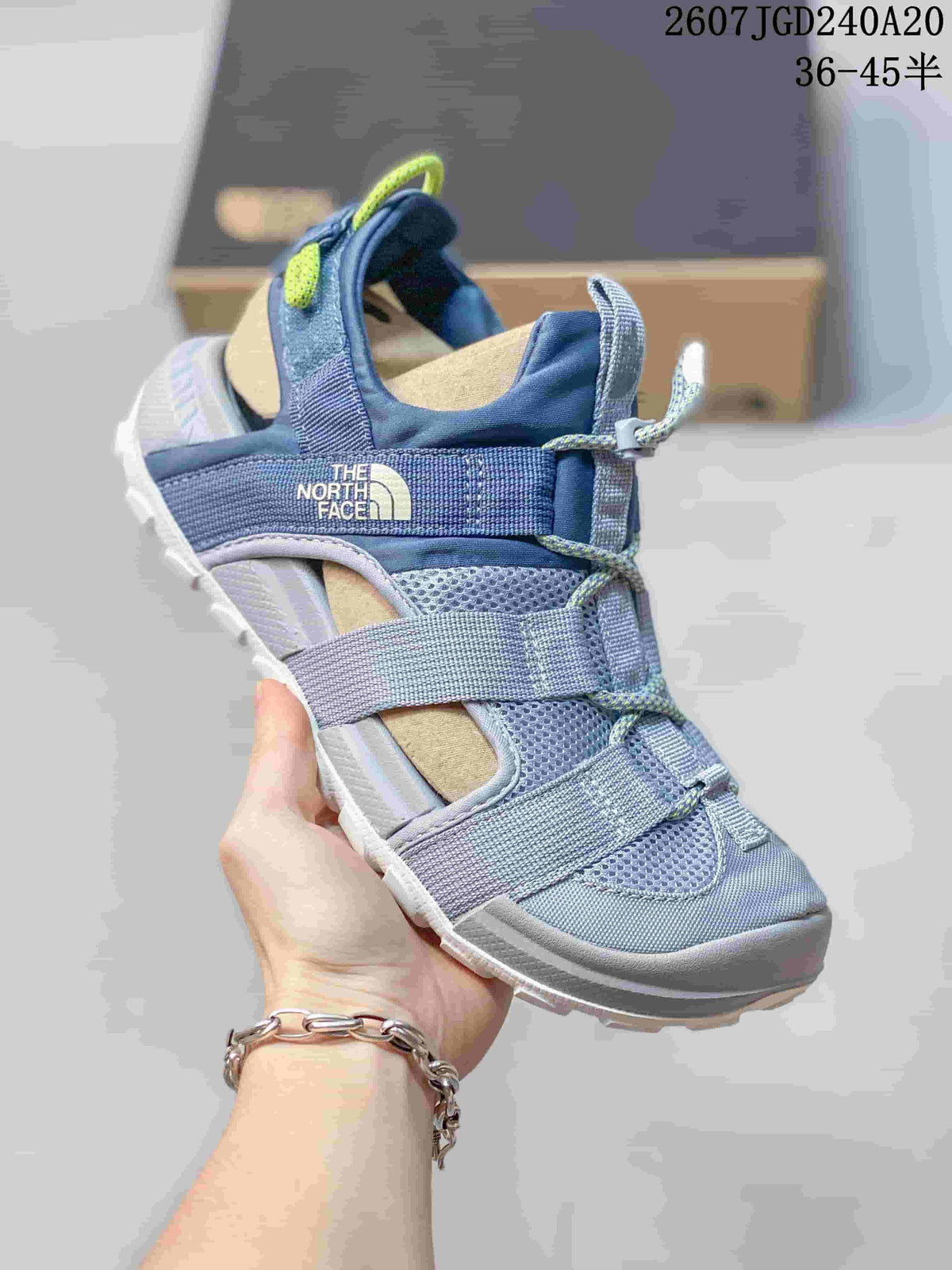 Angled side view of the blue The North Face sandal showing the open design, webbing straps and branded side panel.