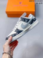 Side profile showing the light grey side panel, white upper, navy patterned overlays, and layered sole.
