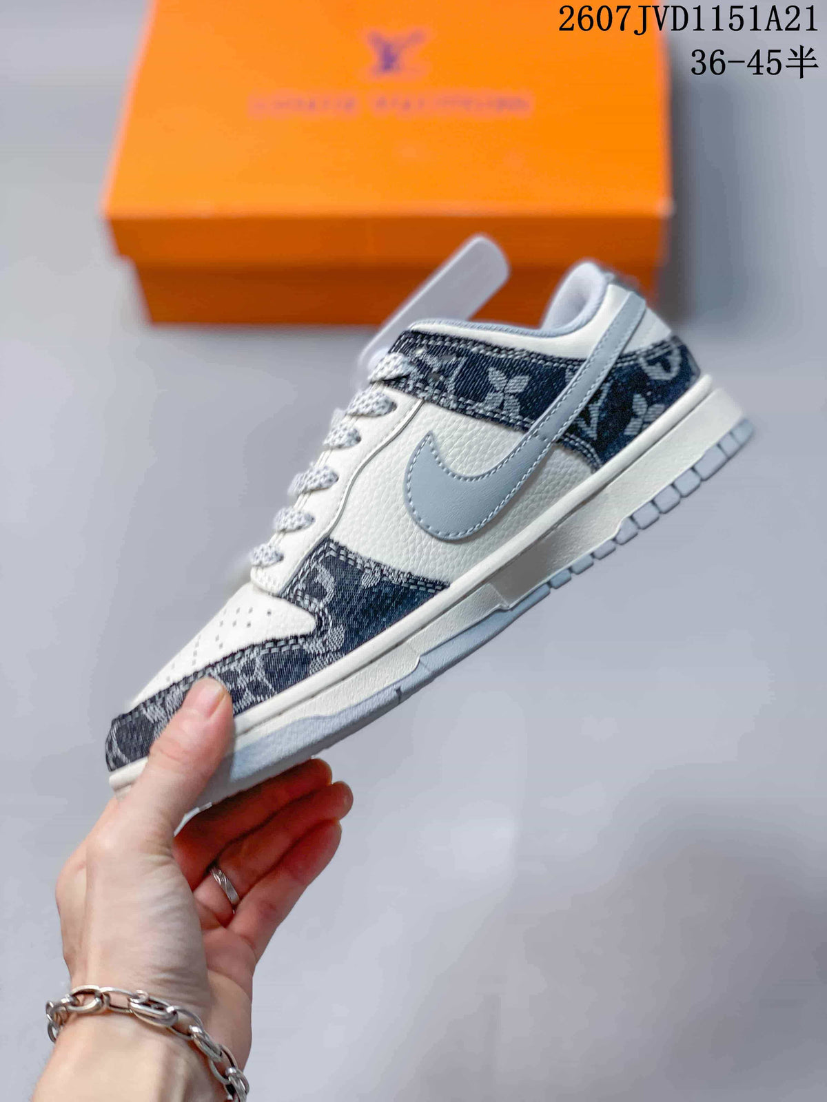 Side profile showing the light grey side panel, white upper, navy patterned overlays, and layered sole.