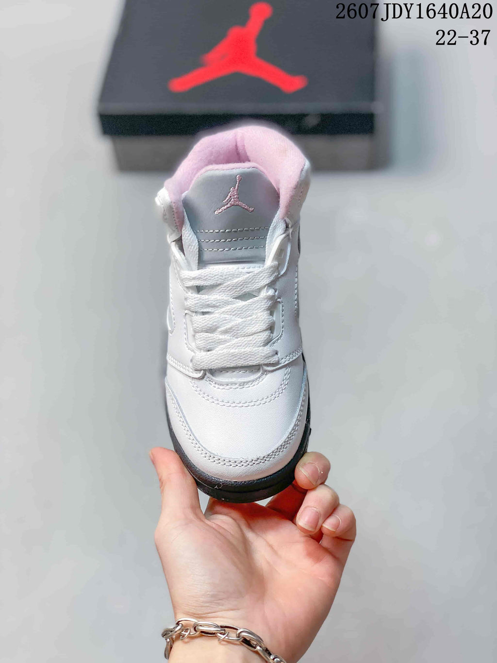 Top view showing the white laces, gray tongue panel, and pink padded collar.