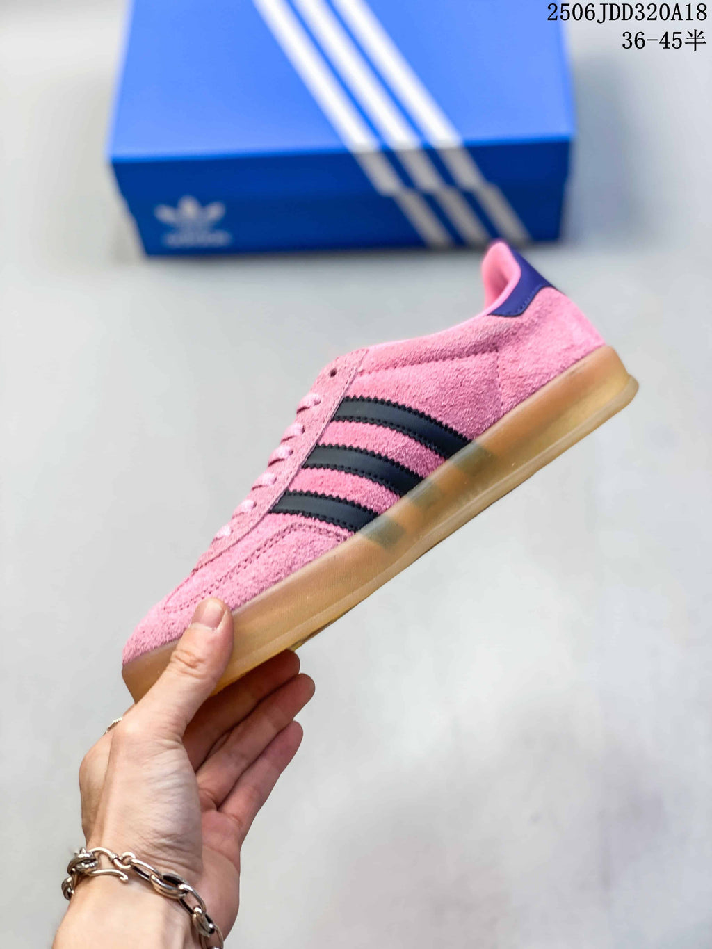 Side profile of the pink sneaker showing black three-stripe detailing and the low-top silhouette.
