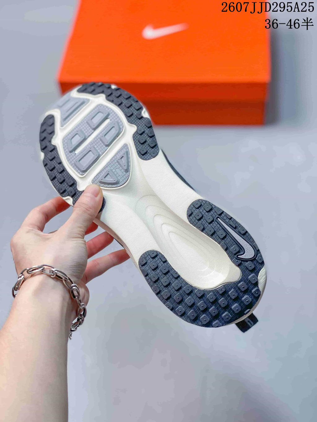 Underside view of the Nike Vomero 18 outsole showing a light-colored central section and dark patterned rubber traction areas.