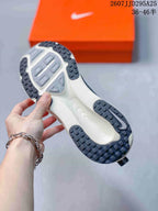 Underside view of the Nike Vomero 18 outsole showing a light-colored central section and dark patterned rubber traction areas.