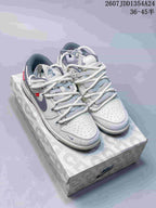 Pair of white and gray Nike Dunk Low Retro sneakers displayed on a patterned shoebox.