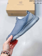 Side view of the sneaker showing the open mesh-style upper, toe overlay, and thick textured midsole.