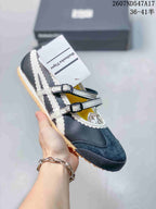 Dark Mary Jane sneaker with contrasting white side stripes, two straps and a tan-colored outsole.
