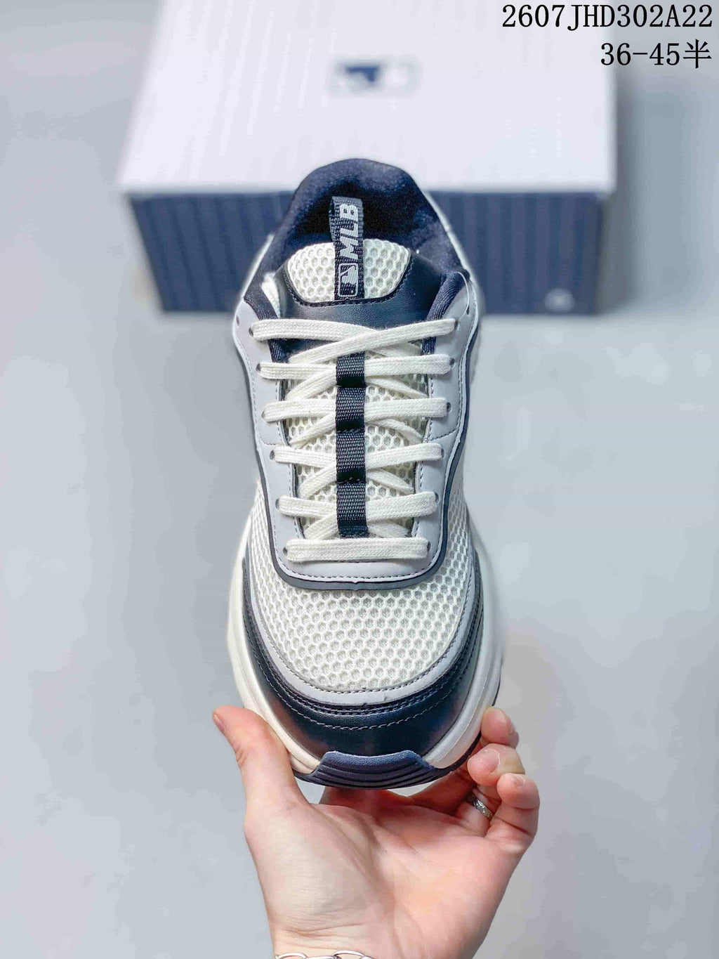 Top view of the sneaker showing white laces, a dark center lace strip, mesh-look toe panel, and padded tongue.