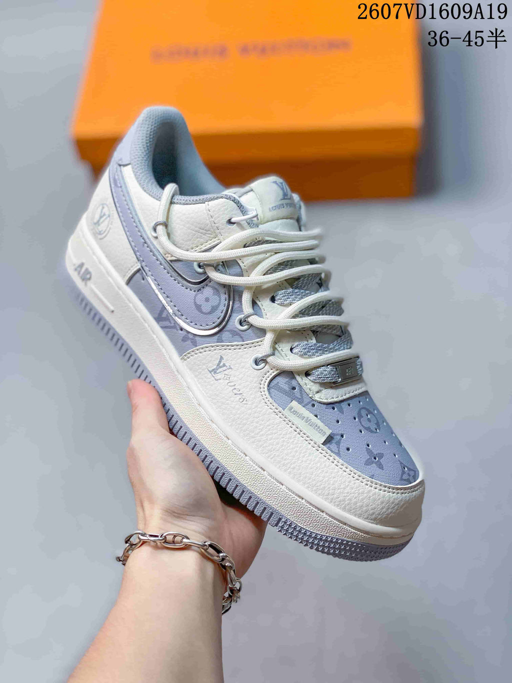 Close-up of a white and lavender sneaker with Louis Vuitton branding, decorative side details, and a pale outsole.