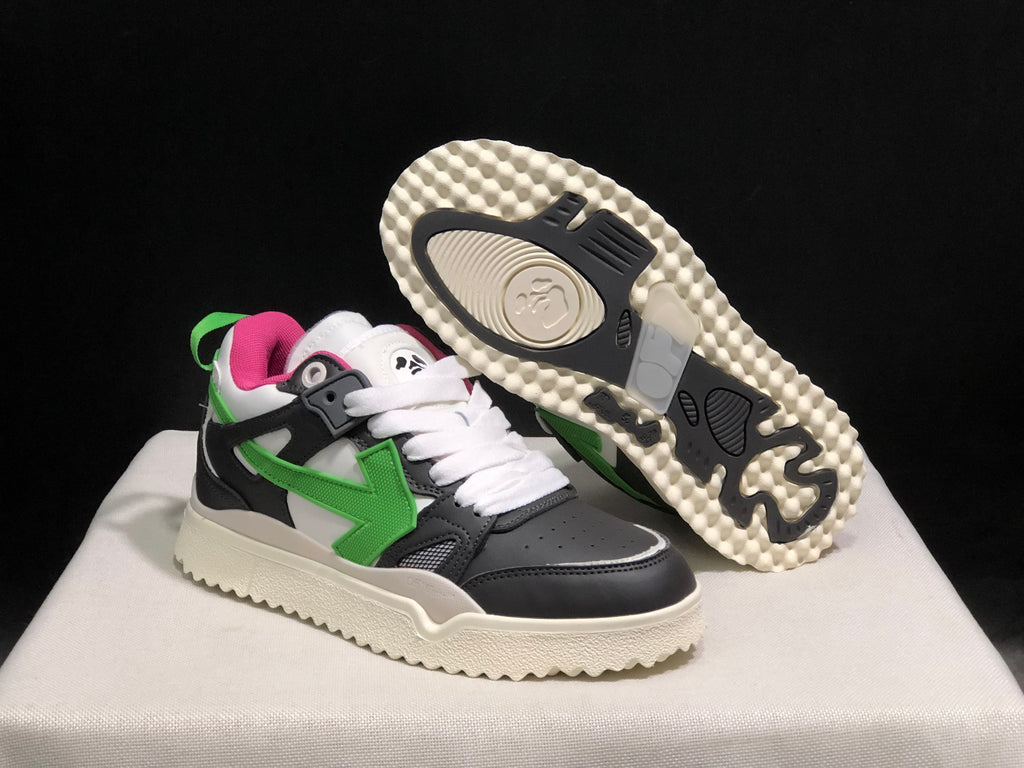 Angled view showing one sneaker lifted to display the patterned outsole and the other sneaker's green side arrow.