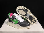 Angled view showing one sneaker lifted to display the patterned outsole and the other sneaker's green side arrow.