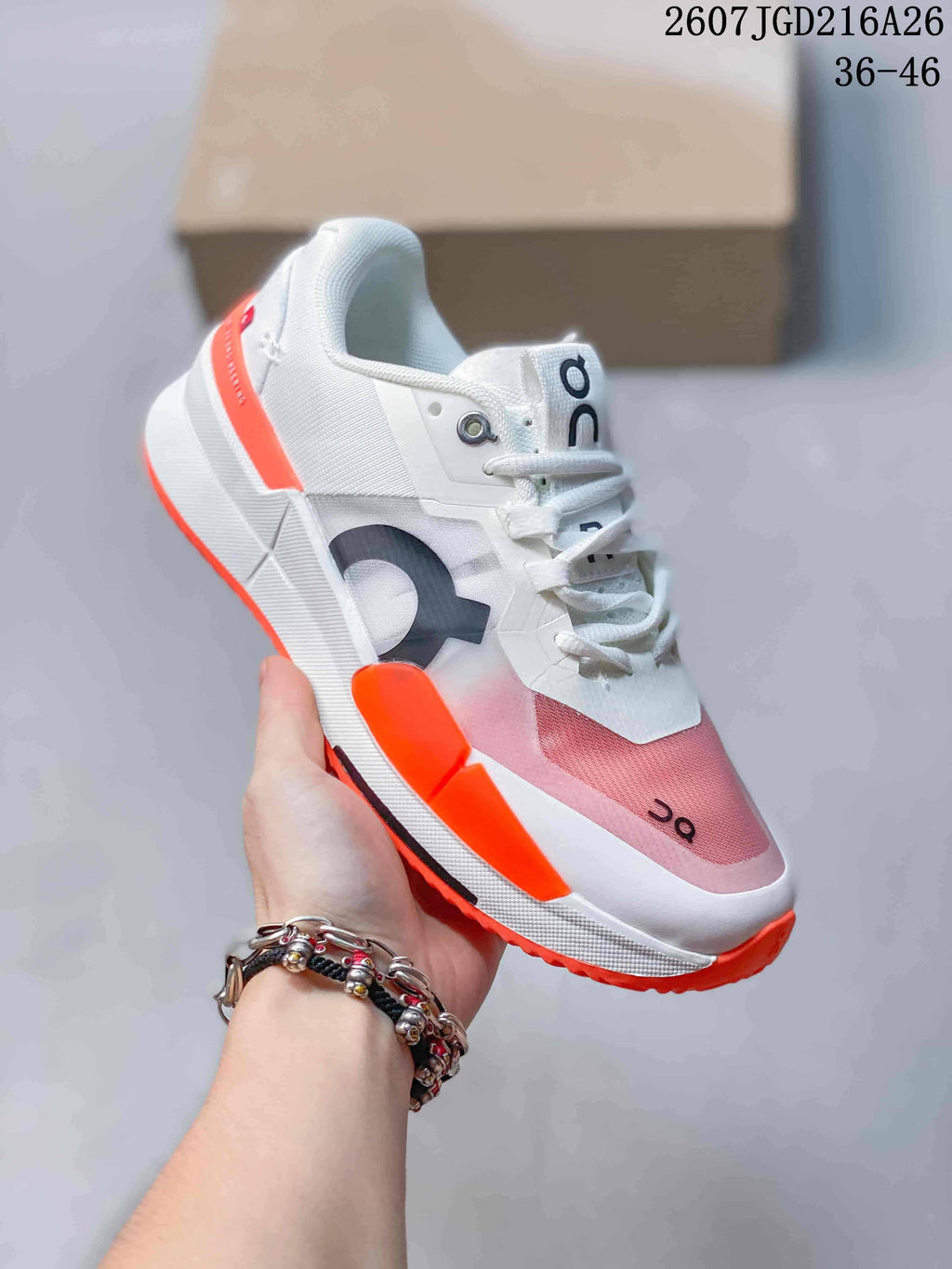 Angled side view of the white, pink and orange On tennis sneaker showing the layered midsole and outsole.