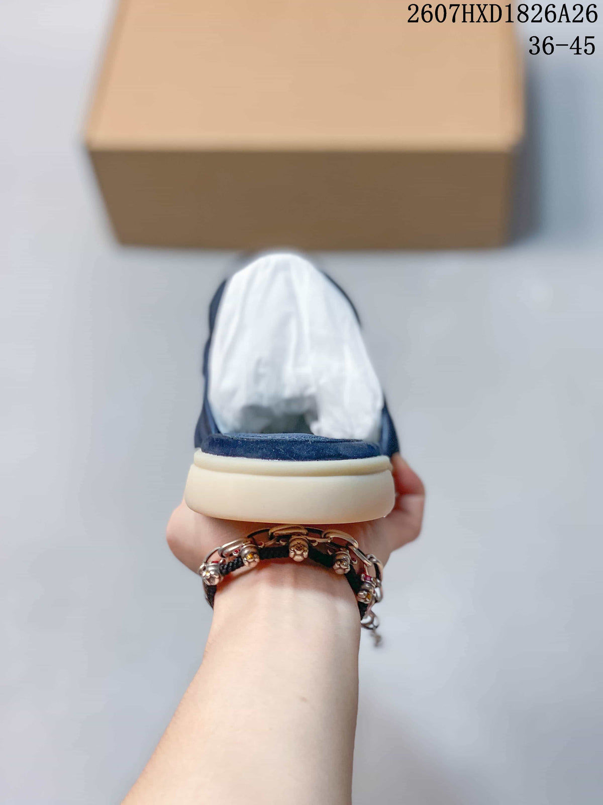 Rear view showing the open-back mule construction, navy upper, cream sole, and white packing paper inside the shoe.