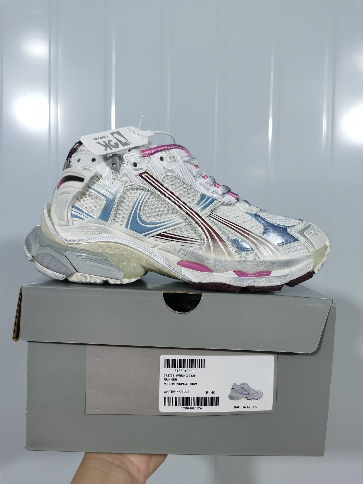 Balenciaga Runner 3120 sneaker in white with pink and blue accents displayed on its box; the box label shows size E 40.