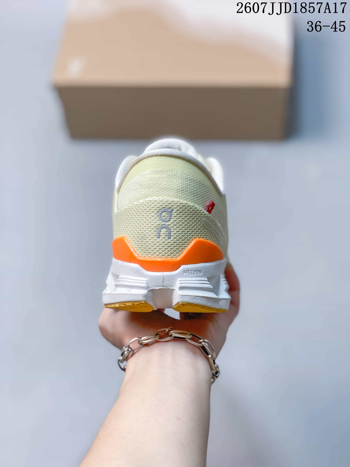 Rear view of the sneaker showing the cream heel, orange accent panel, padded collar, and white outsole.