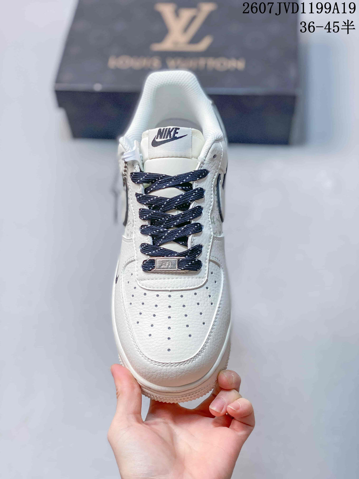 Top view of the white sneaker showing the perforated toe box, dark blue laces, and metal lace accessory.