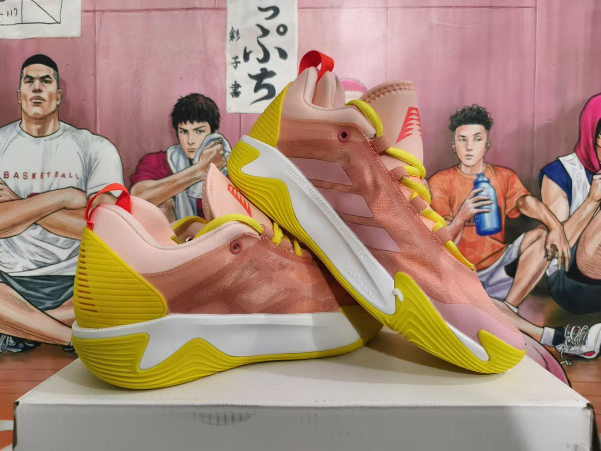 Pair of pink and yellow basketball sneakers shown from the side