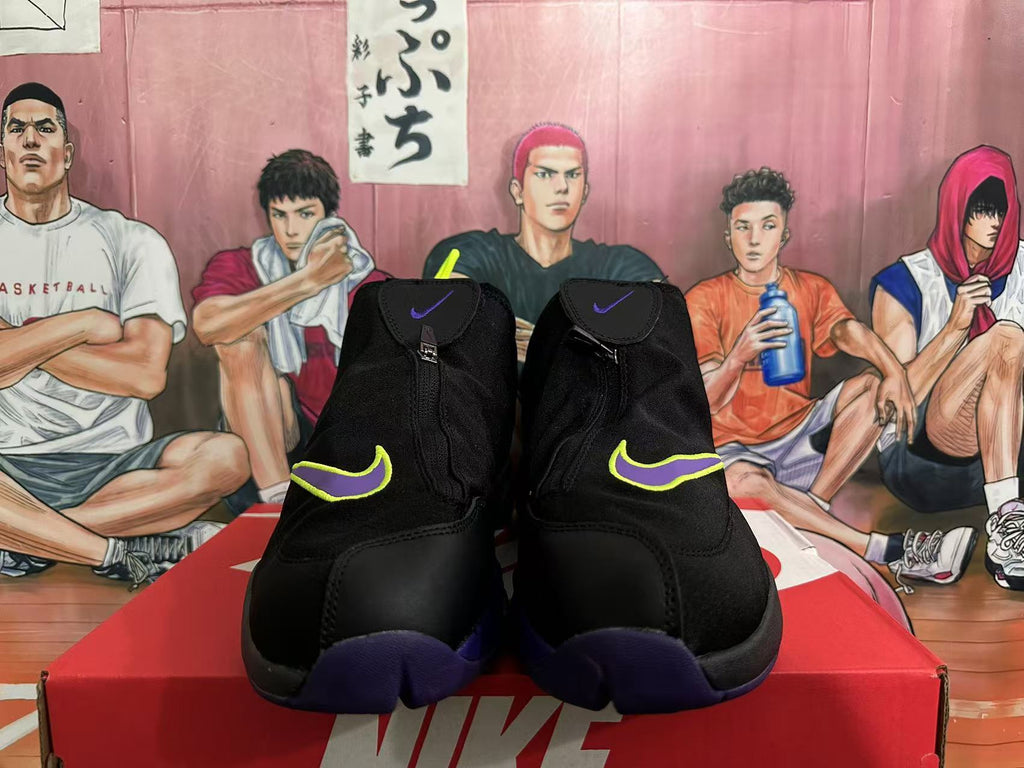 Front view of black Nike high-top basketball sneakers showing purple and neon yellow Swoosh accents and zippered closures.