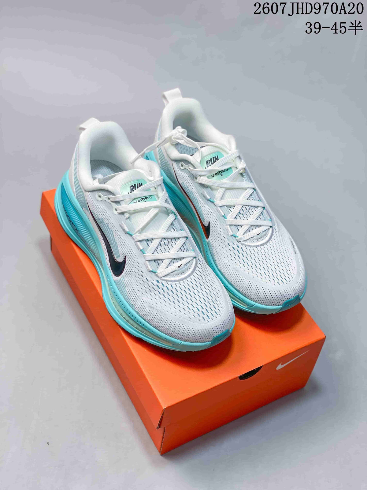 Pair of white and turquoise Nike Structure Plus sneakers displayed on an orange shoebox; overlay text shows style code 2607JHD970A20 and size range 39–45.