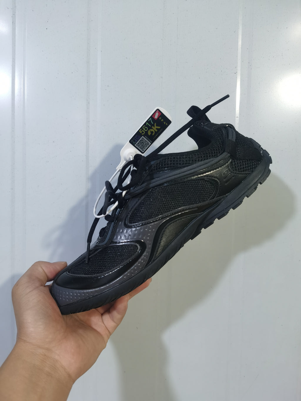 Black Balenciaga Radar sneaker shown from an angled side view, highlighting the mesh panels, layered overlays, laces, and rugged outsole.