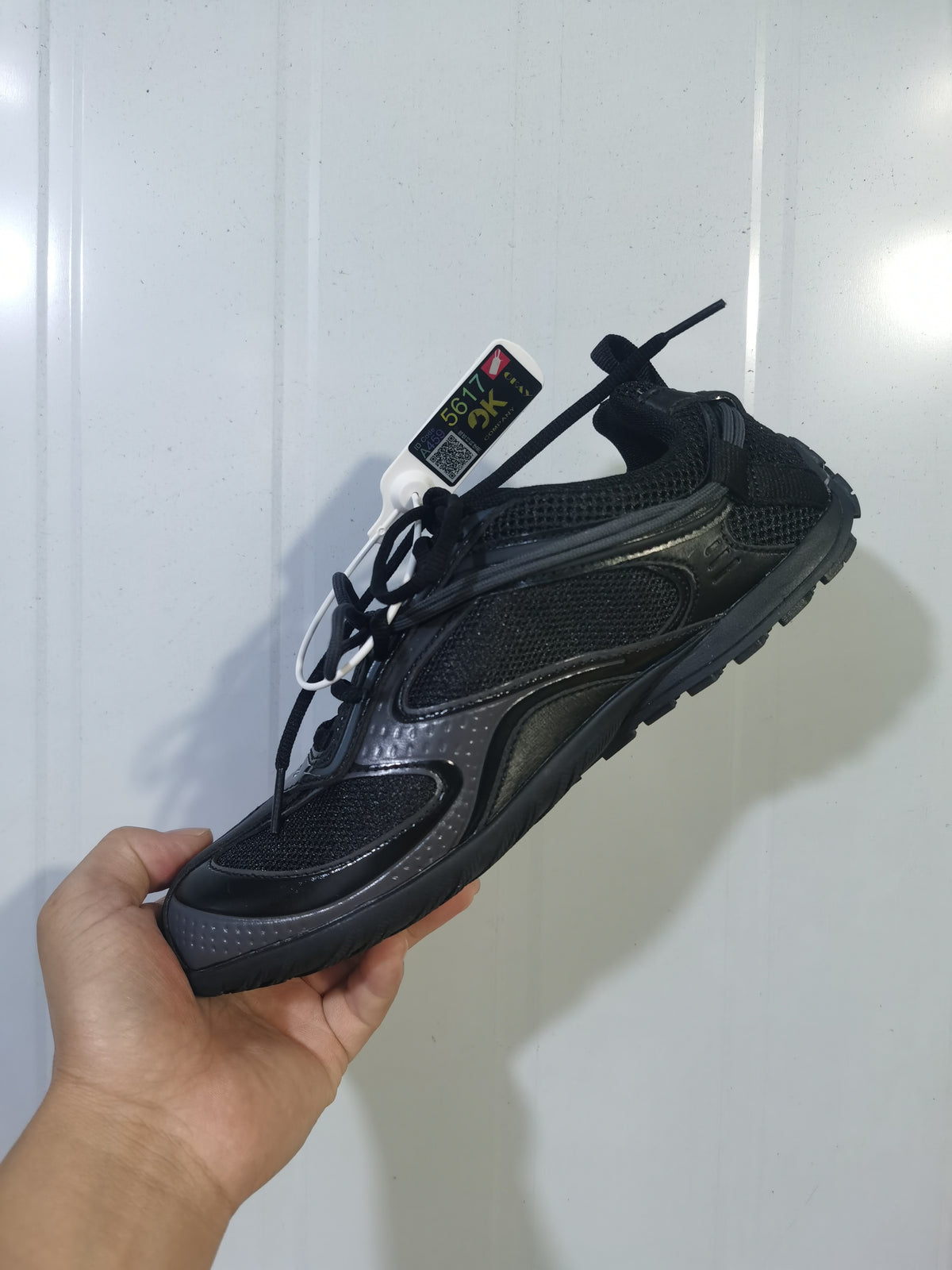 Black Balenciaga Radar sneaker shown from an angled side view, highlighting the mesh panels, layered overlays, laces, and rugged outsole.