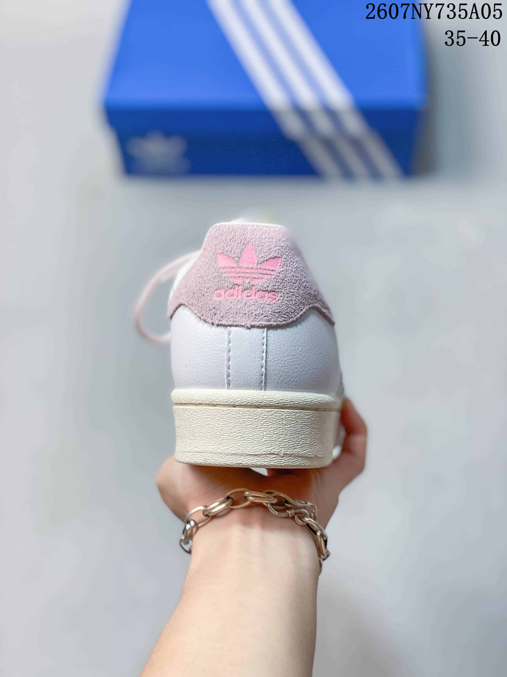 Rear view of the sneaker showing the pink Adidas heel patch and cream-colored sole.