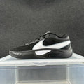Side view of a black low-top Nike sneaker with white side detailing and a dark sculpted sole.