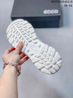 Close view of the white sneaker outsole showing a chunky geometric tread pattern.