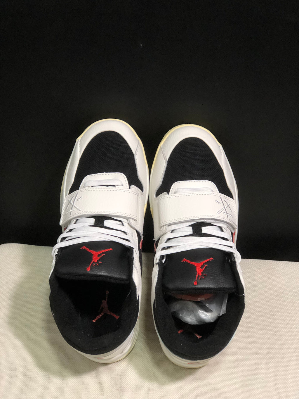 Top view showing white laces, adjustable midfoot straps, black tongues, and red tongue logos.