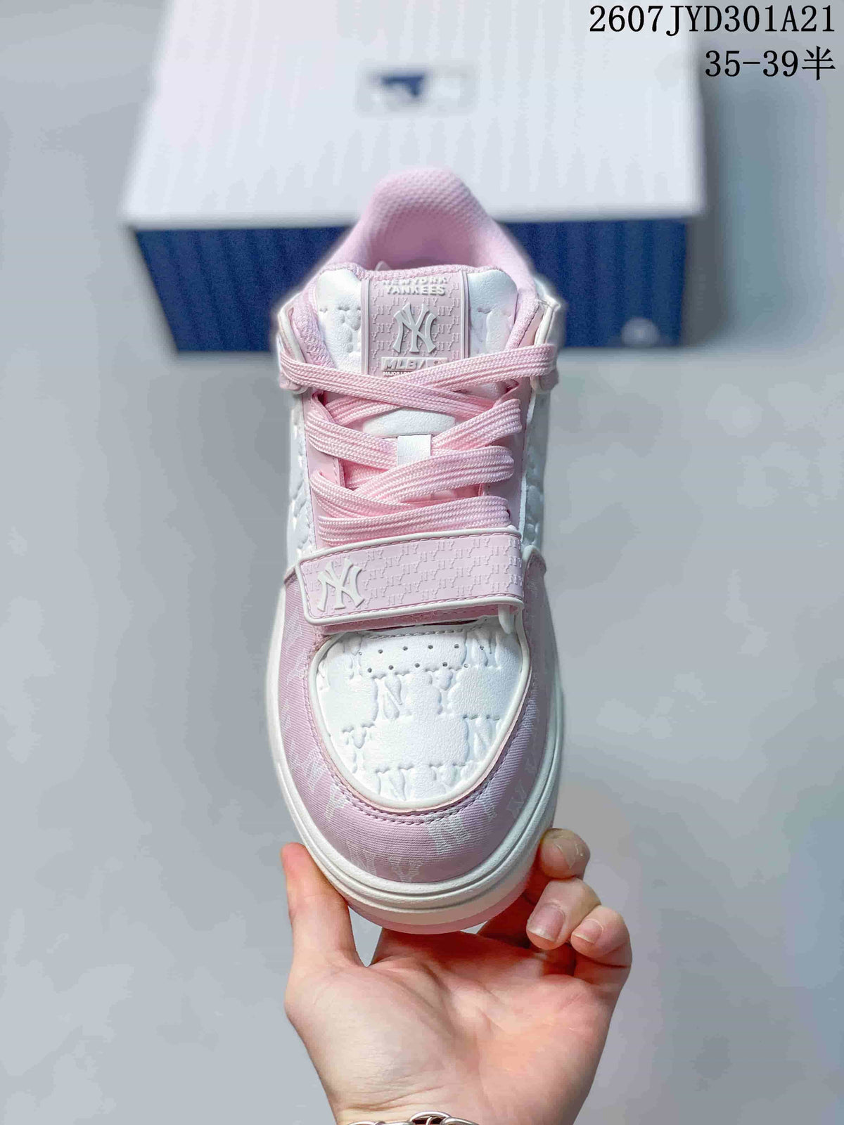 Top view of a pink and white sneaker with laces, a hook-and-loop strap, and New York Yankees branding.