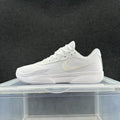 White low-top Nike sneakers with a mesh-like upper, lace-up closure, and Zoom marking, shown from the side.