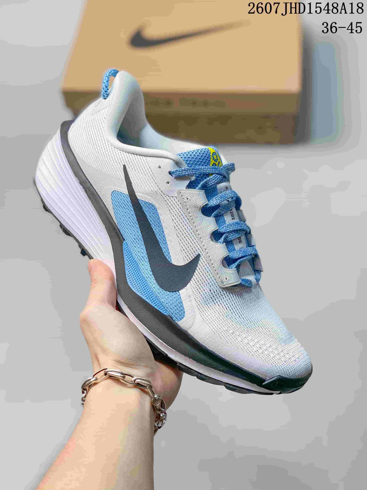 White and blue Nike ReactX Pegasus ACG Trail 6 sneaker shown from a side and front angle.