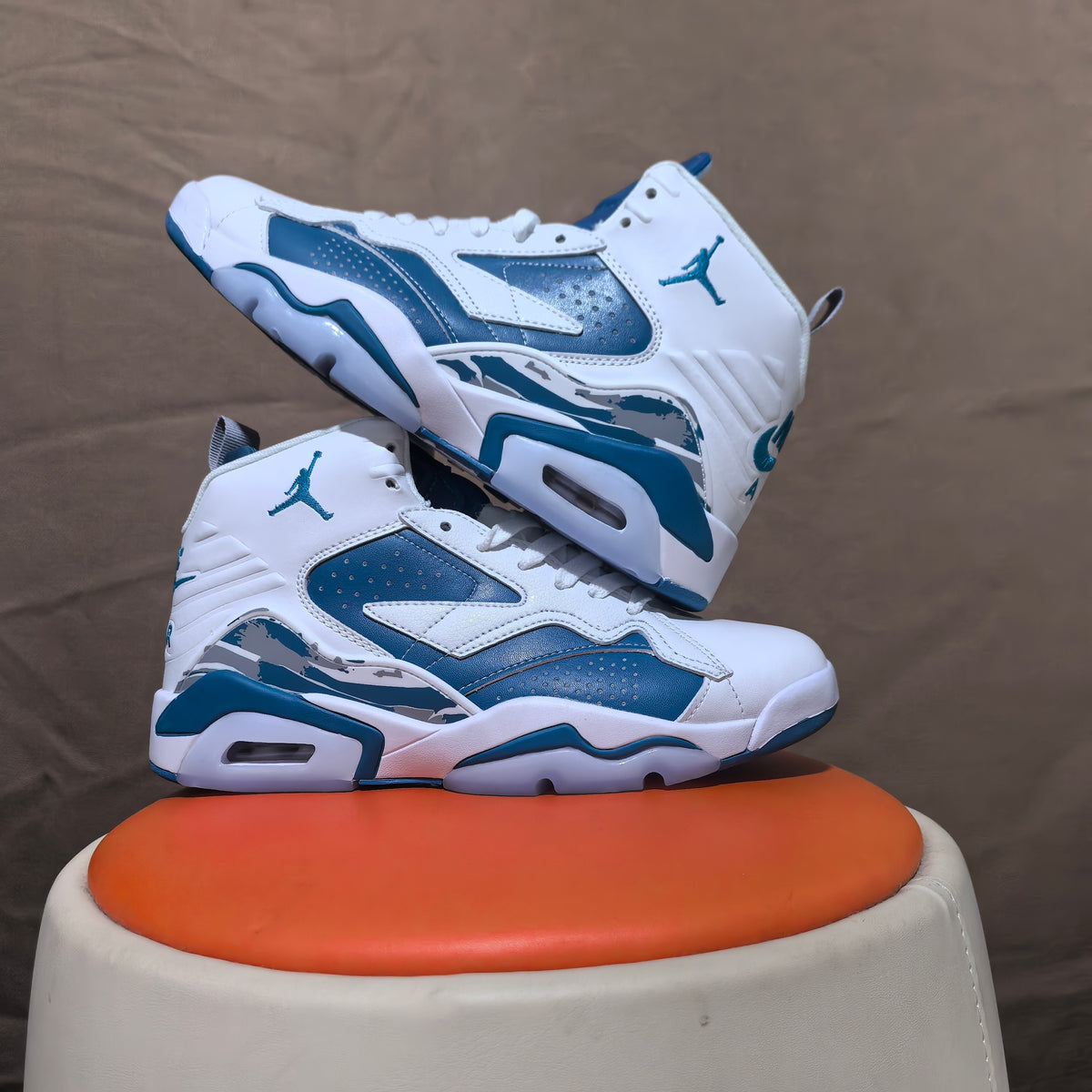 Two white and blue high-top sneakers shown from side angles