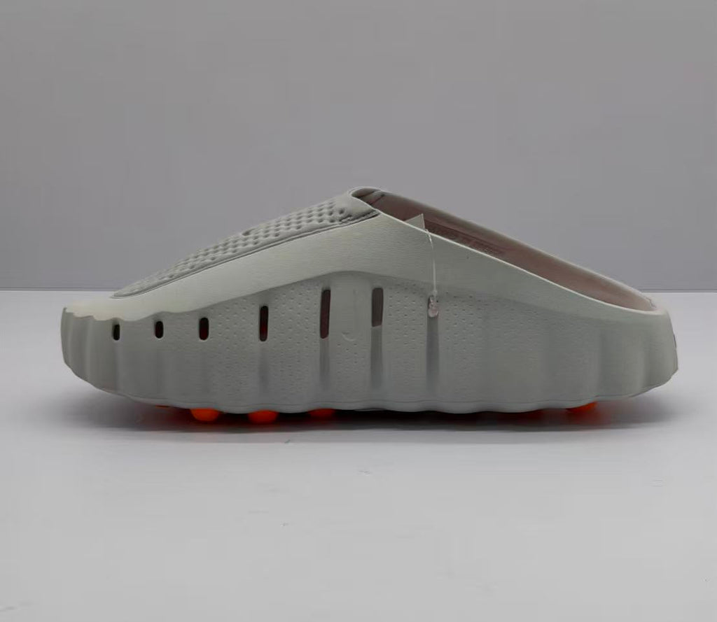 Side view of the gray slide sandal showing ventilation openings along the upper and the raised outsole profile.