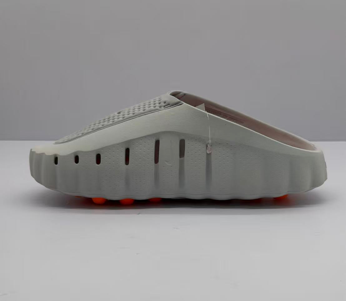 Side view of the gray slide sandal showing ventilation openings along the upper and the raised outsole profile.