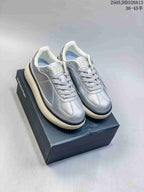 Pair of metallic silver Onitsuka Tiger Delecity low-top sneakers on a box