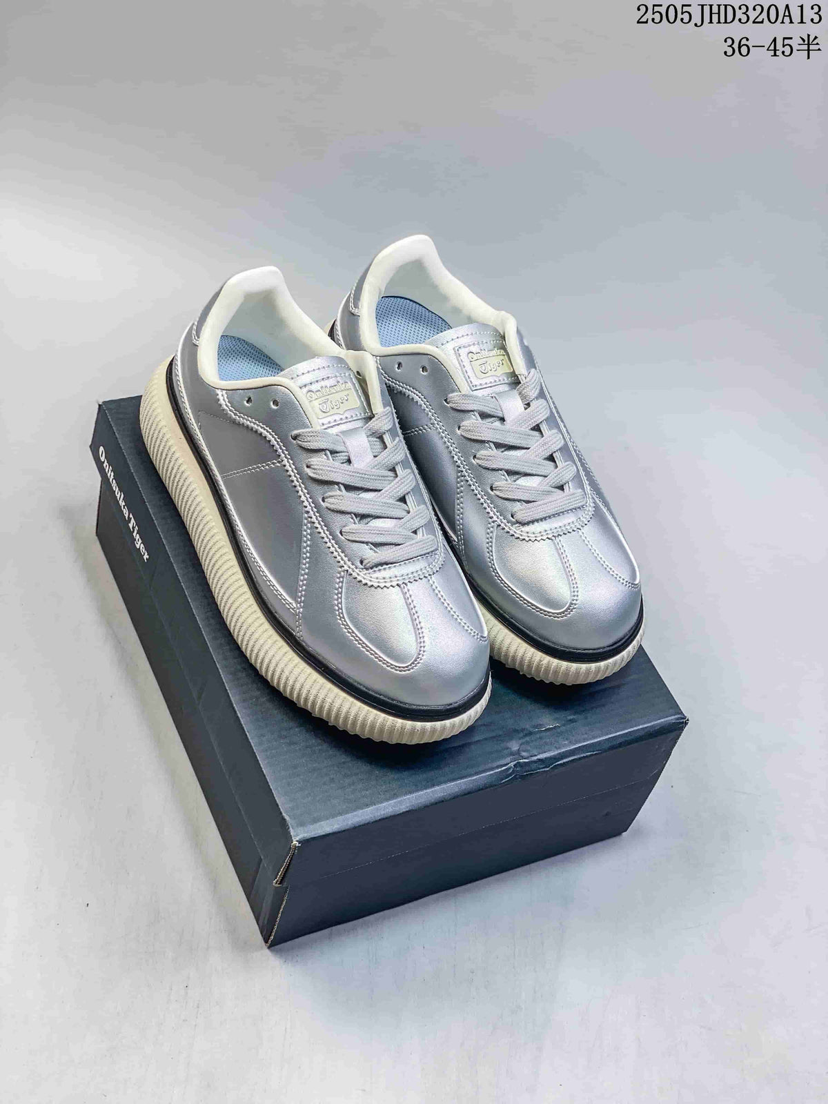 Pair of metallic silver Onitsuka Tiger Delecity low-top sneakers on a box