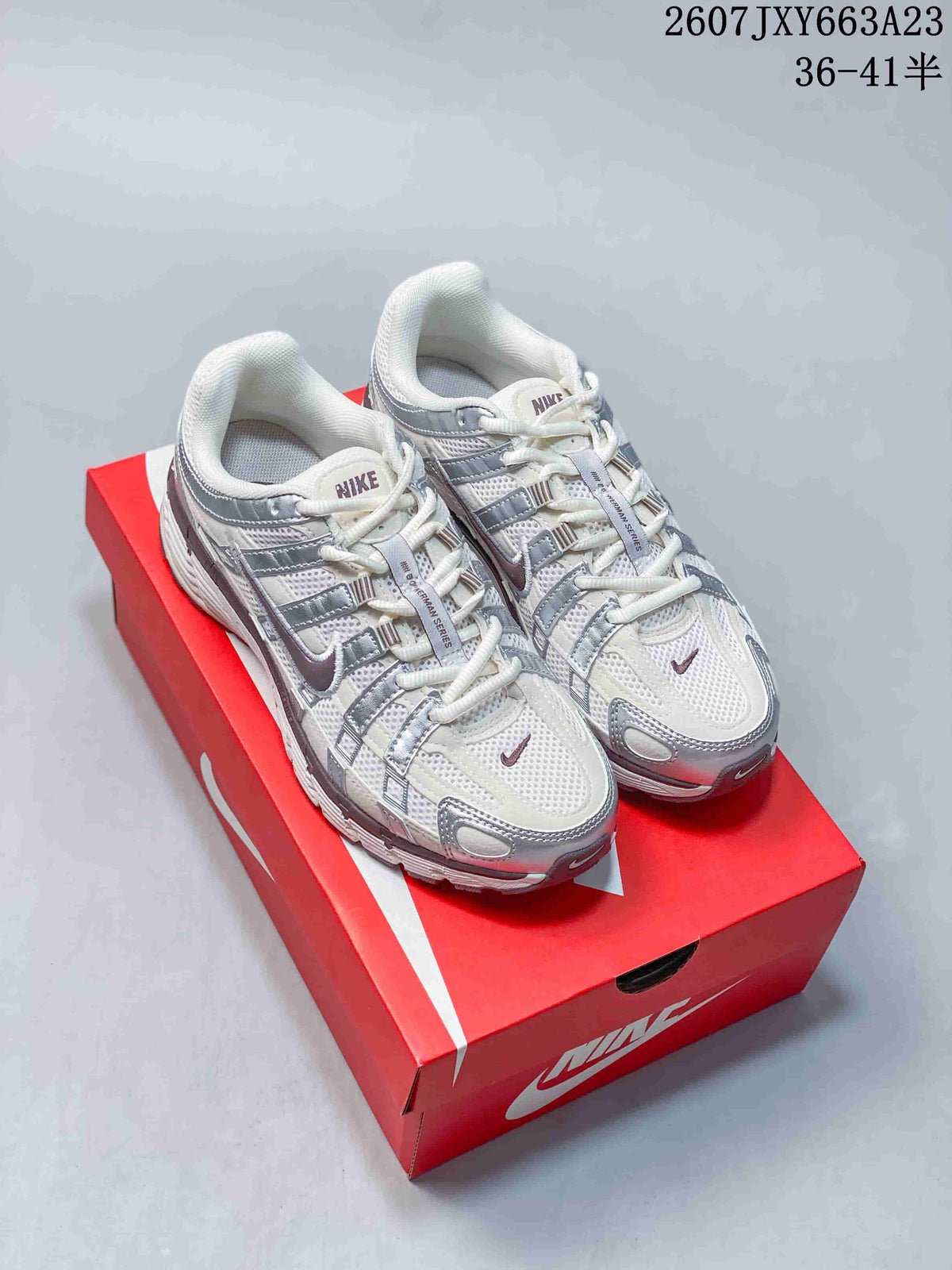 Pair of white and silver Nike P-6000 sneakers displayed on a red Nike shoebox.