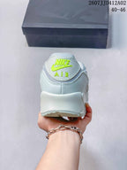 Rear view showing the Nike Air logo and heel of the pale-colored sneaker.