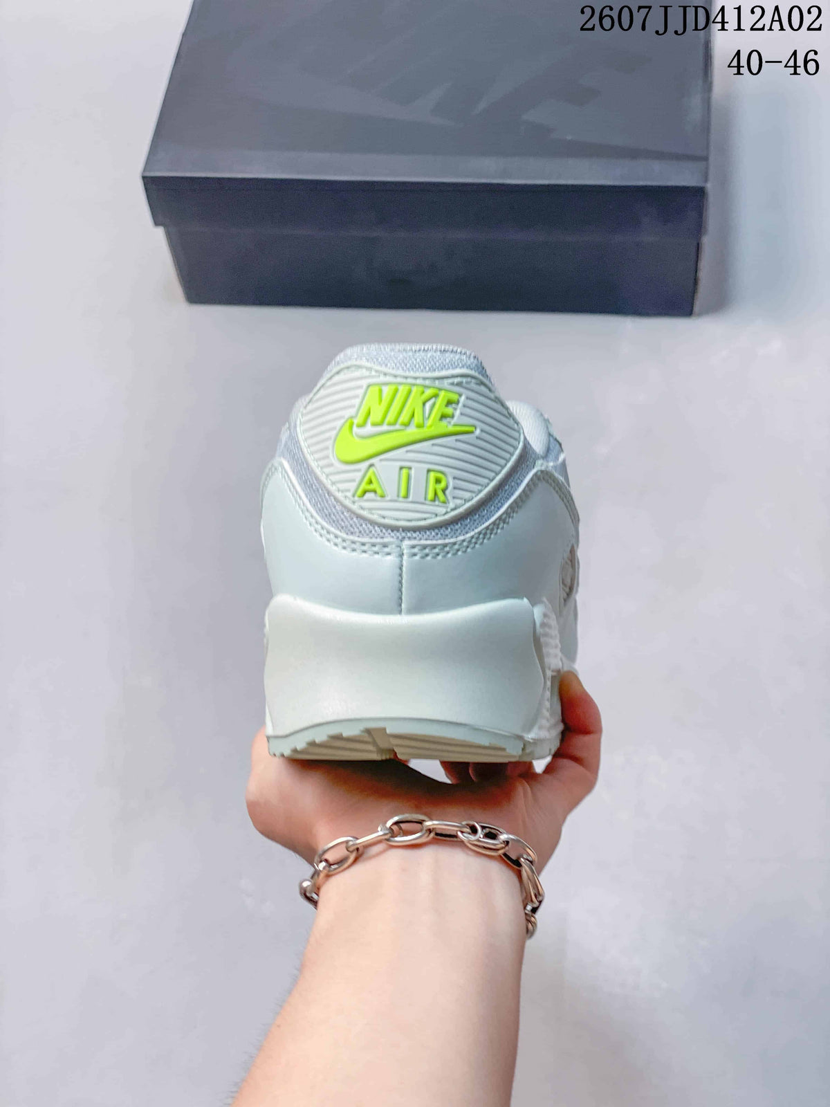 Rear view showing the Nike Air logo and heel of the pale-colored sneaker.