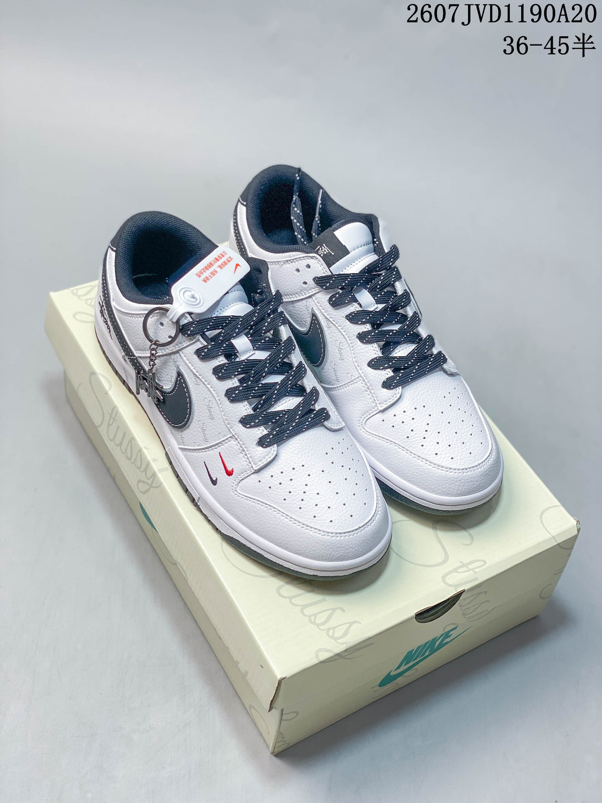 Pair of white and black Nike low-top sneakers displayed on a branded shoe box, with product code and size range text visible above.