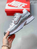 Side profile highlighting the layered silver upper, contrasting accents, and structured midsole.