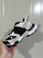 Rear and side view showing the layered heel, mesh sections, contrasting overlays, and chunky outsole of the Balenciaga sneaker.