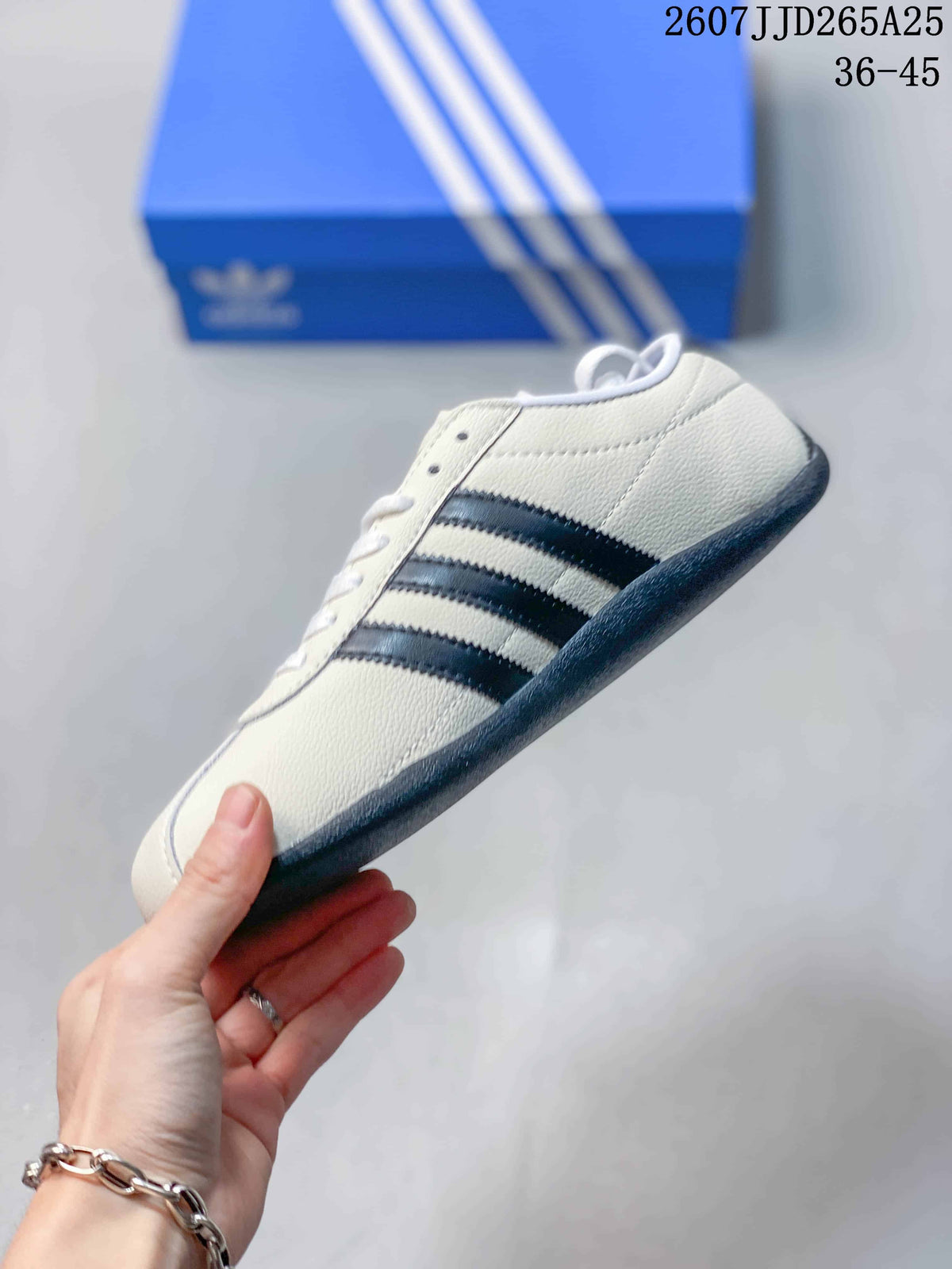 Side profile of the white low-top sneaker showing three black side stripes and a dark outsole.
