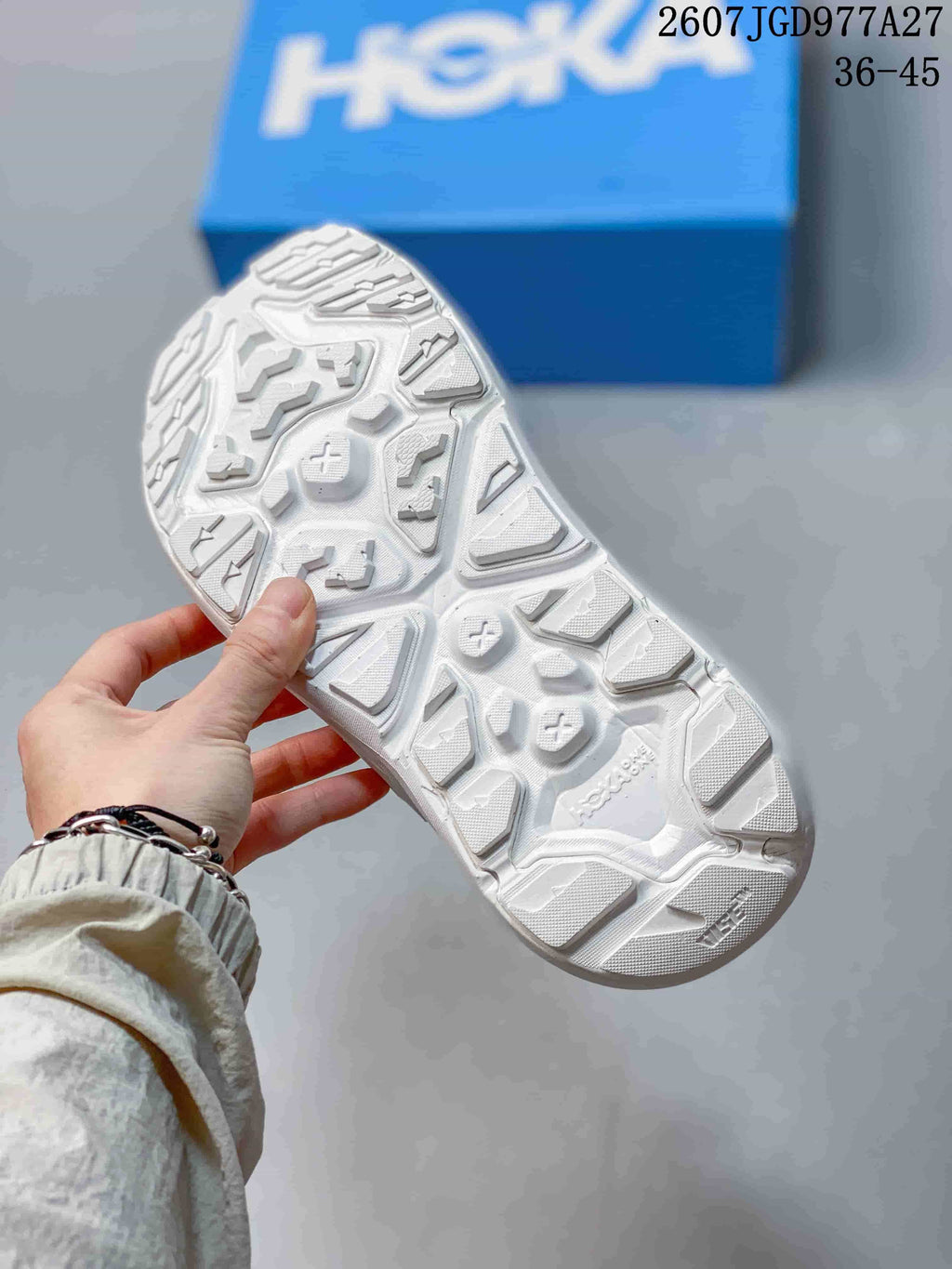 Close view of the white sandal outsole showing a rugged, multidirectional lug pattern.
